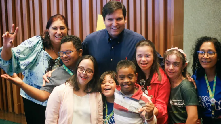 Robério Negreiros com pessoas com deficiência e familiares em solenidade na Câmara Legislativa, em dezembro de 2023
